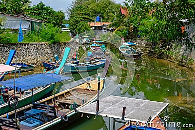 Thailand. Phuket - 01/05/18. Traditional wooden longboats of fishermen staying on anchor in canal Editorial Stock Photo