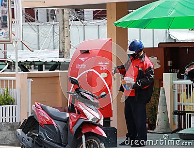 Thailand Post Officer unlocking the postbox to take the letter out with hygienic masked to prevent coronavirus or Covid 19 Editorial Stock Photo