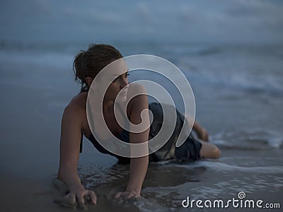 Thailand young woman lying in surf on beach Stock Photo