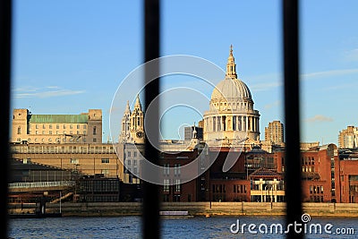 Thames river view with riverside buildings and st pauls cathedral dome look through blurred rail Stock Photo
