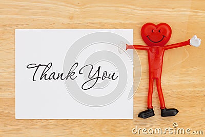 Thank you greeting card on a desk with a happy smiling heart Stock Photo