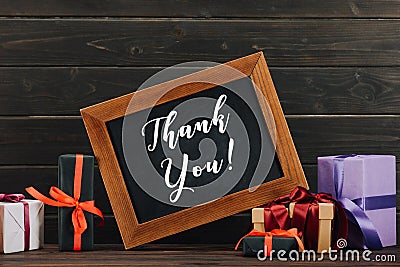 thank you lettering on chalkboard in frame with various gift boxes against Stock Photo