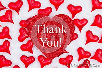 Thank you message on glitter heart with red hearts on white fabric Stock Photo