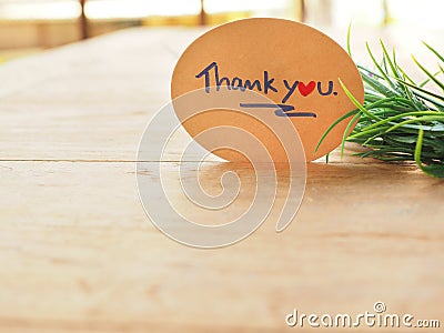 The thank you message is handwritten on a brown oval paper Stock Photo