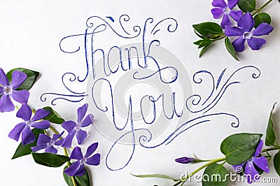 Thank you note surrounded by purple flowers Stock Photo