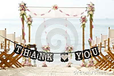 Thank you words banner at beautiful beach wedding set up chairs Stock Photo