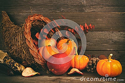 Thanksgiving cornucopia with pumpkins and apples against wood Stock Photo