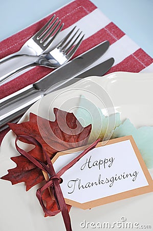 Thanksgiving dining table place setting in modern pale blue, red and white theme - closeup. Stock Photo