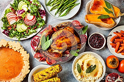 Thanksgiving dinner table with roasted whole chicken or turkey, green beans, mashed potatoes, cranberry sauce, grilled vegetables Stock Photo