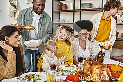 Thanksgiving feast, positive multiethnic friends and Stock Photo