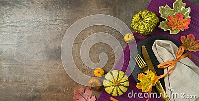 Thanksgiving party banner concept with plate, pumpkin and autumn leaves on dark background. Top view, flat lay Stock Photo