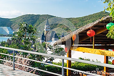 Thatch roof with colorful Chinese lanterns with flowers the background of the hill Stock Photo