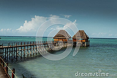 Thatched huts on wooden pier, Zanzibar Stock Photo