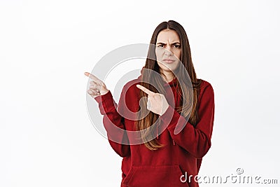 Thats gross, disgusting. Displeased grimacing woman frowning and pointing aside at something strange, express dislike Stock Photo