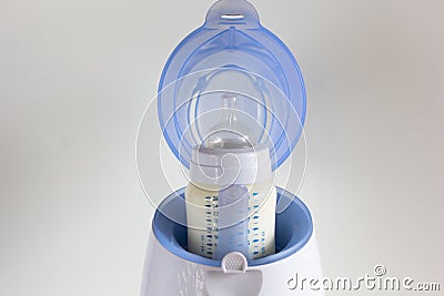 Thawing breast milk in the bottle warmer Stock Photo