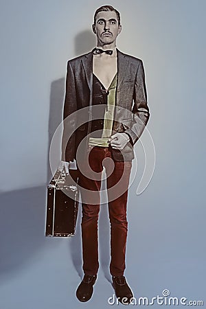 Theater actor holds a suitcase in his hand Stock Photo