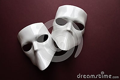 Theatre concept with the white masks on trendy vinous bordeaux, burgundy background. Anonimous, Incognito, Conspiracy concept. Stock Photo