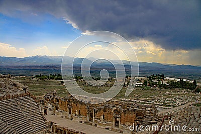 Looking towards the stage of the theatre, Hierapolis with dark storm clouds on the horizon Stock Photo