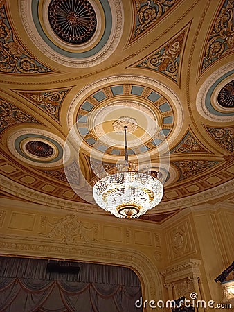 Theatrical interior. Beautiful, large crystal chandelier in a classic style. Chandelier on the ceiling in the theater. Stock Photo