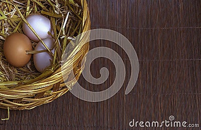 Thee easter eggs in the basket on wooden mat background Stock Photo