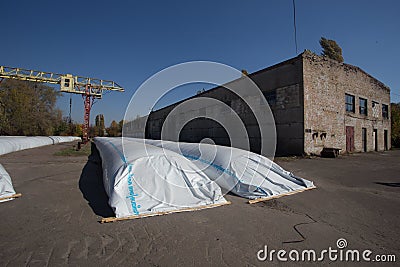 The theme is industry and agrarian. The grain harvest is stored in large, moisture-proof, sealed white bags in the open air Editorial Stock Photo