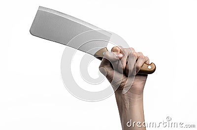 The theme of the kitchen: Chef hand holding a large kitchen knife for cutting meat on a white background isolated Stock Photo