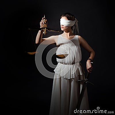 Themis, goddess of justice blindfolded, with scales and a sword in her hands. Stock Photo