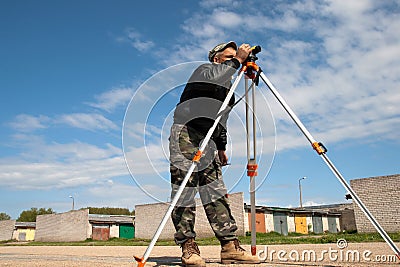 Theodolite on a tripod with construction worker Stock Photo