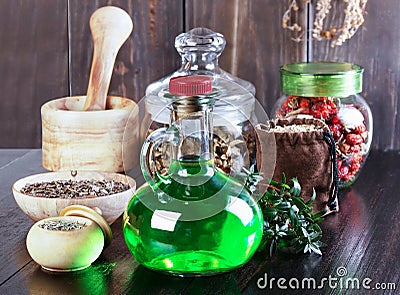 Therapeutic herbal tincture, alternative medicine, love potions, dried herbs on a wooden table. Stock Photo