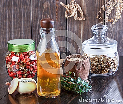 Therapeutic herbal tincture, alternative medicine, love potions, dried herbs on a wooden table. Stock Photo