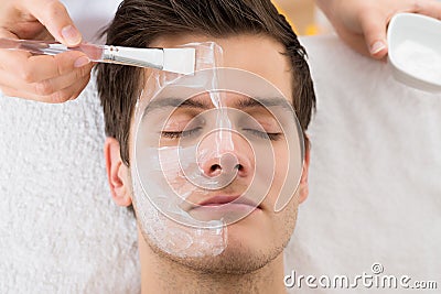 Therapist Applying Face Mask To Man Stock Photo
