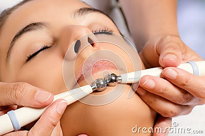 Therapist applying low frequency galvanic electrodes on face. Stock Photo