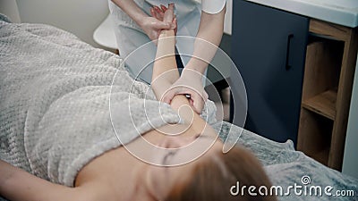 A therapist massaging hands of a woman in the cabinet Stock Photo
