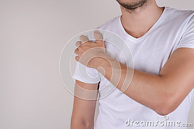 Therapy treatment ill concept. Sad upset stressed unhappy man touching shoulder isolated on gray grey background copy space Stock Photo