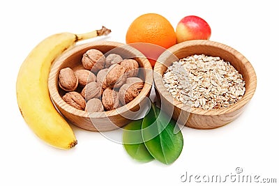 There are Banana,ApÐ·le,Orange with Walnuts in the Wooden Plate and Rolled Oats,with Green Leaves,Healthy Fresh Organic Food Stock Photo