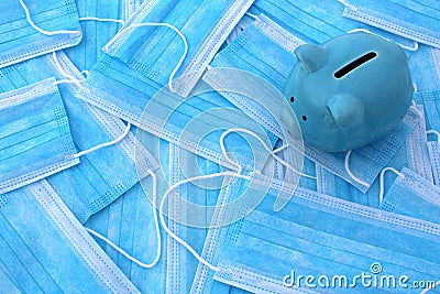 There is a blue piggy bank on the medical masks. Stock Photo