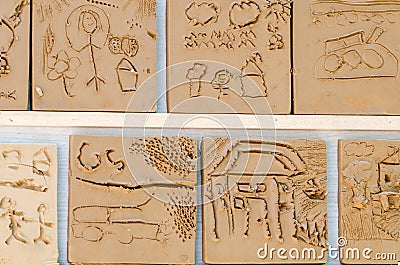 There are children`s pictures on the clay at the ceramic worksho Stock Photo