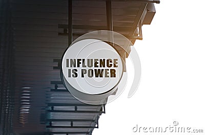 There is a circular sign under the roof of the building that says - Influence is Power Stock Photo