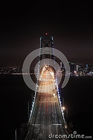 Bay Bridge Illuminated in the Night and San Francisco Blanketed by the Clouds Stock Photo