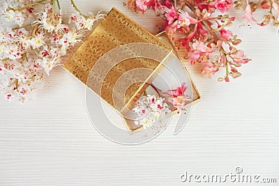 There Gold Open Box with White and Pink Branches of Chestnut Tree are on White Table,Top View.Toned Stock Photo