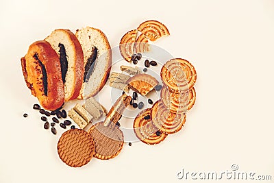 There are Pieces of Roll with poppyseed,Cookies,Halavah,Chocolate Peas,Tasty Sweet Food on the White Background,Top View,Toned Stock Photo