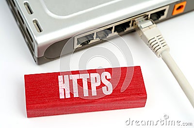 There is a router connected to the network on the table, next to a plaque with the inscription - HTTPS Stock Photo