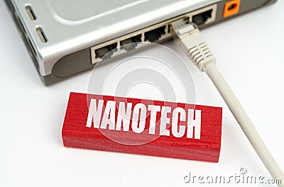 There is a router connected to the network on the table, next to a plaque with the inscription - nanotech Stock Photo