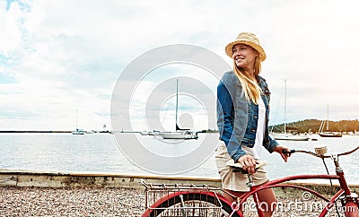 There seems to be no traffic today. a cheerful young getting ready to ride her bicycle while looking in a certain Stock Photo