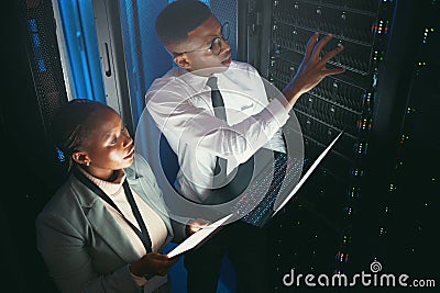 There seems to be problem with this unit. two young IT specialists standing in the server room and having a discussion Stock Photo