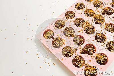 There is a silicone mold filled with chocolate mixture on the table. Stock Photo