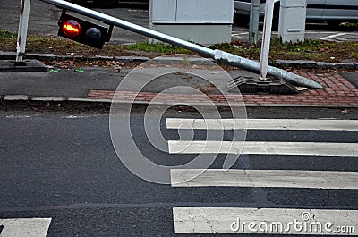 There was a car accident and a traffic light at the pedestrian crossing. galvanized pipe post with pedestrian symbol lights lies r Stock Photo