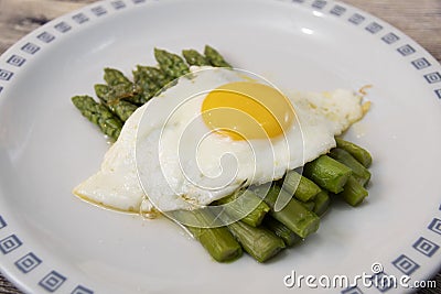 Fried egg with asparagus. Milanese traditional dish. Stock Photo