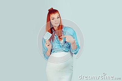 Woman in expectancy pointing to pills Stock Photo