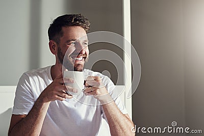 Theres so much to love about a fresh cuppa coffee. a handsome young man drinking coffee in the bedroom at home. Stock Photo
